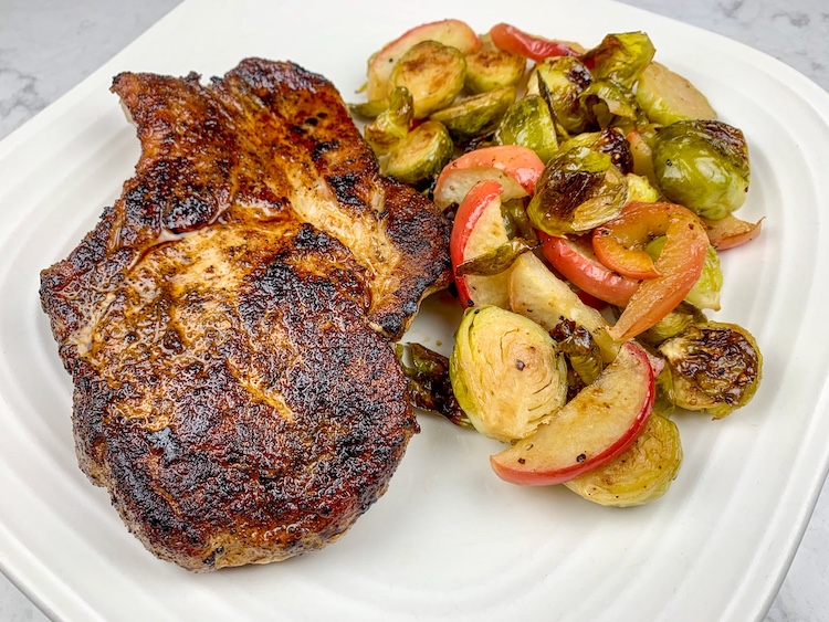 ayesha curry’s easy pork chops with apples and brussels sprouts finished dish on a plate