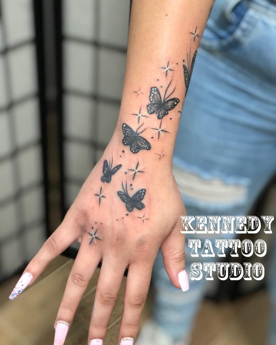 Butterfly going up hand tattoo with stars