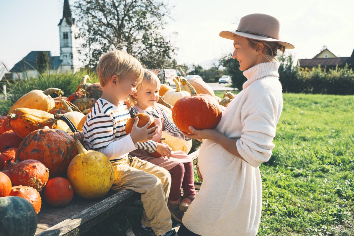 mother showing kids pumpkins