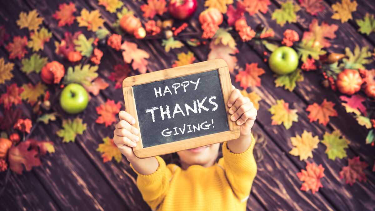 young child happy thanksgiving sign