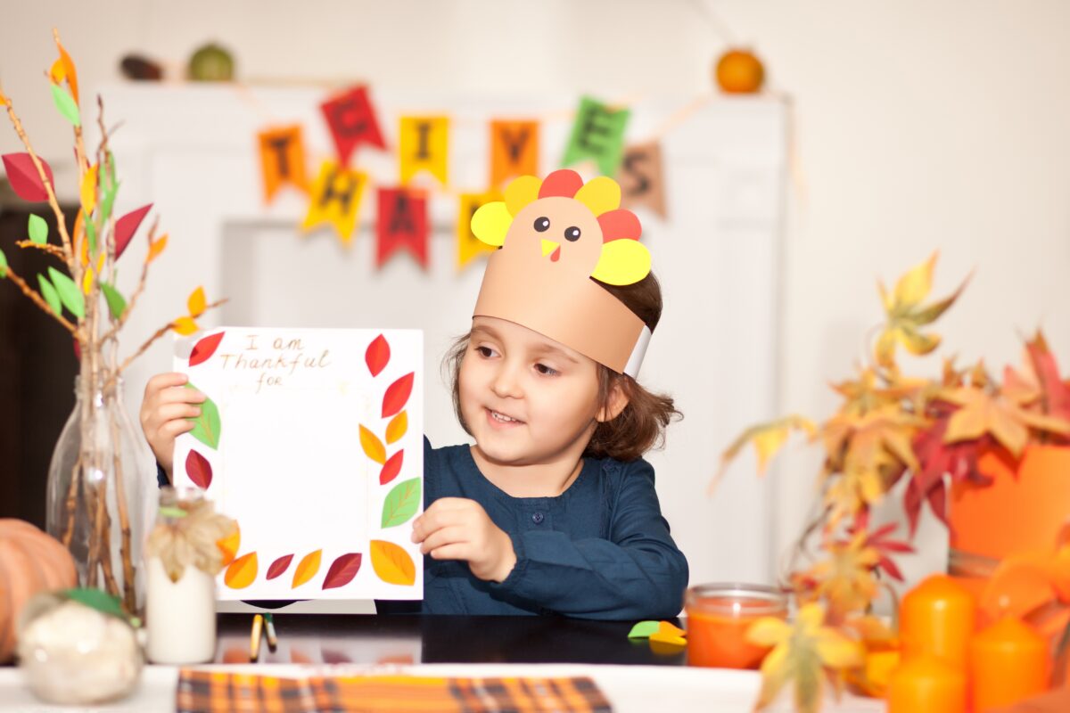 young child making thanksgiving art