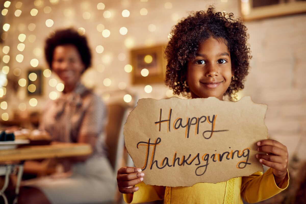 young girl happy thanksgiving sign